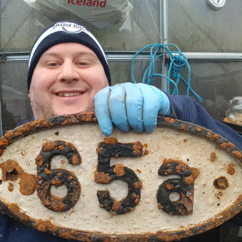 Magnet fisherman Scott Bryant with a sign of the times