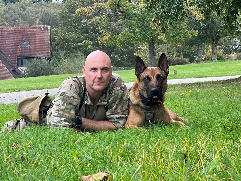 Matt Shaw lying on the grass with one of his dogs