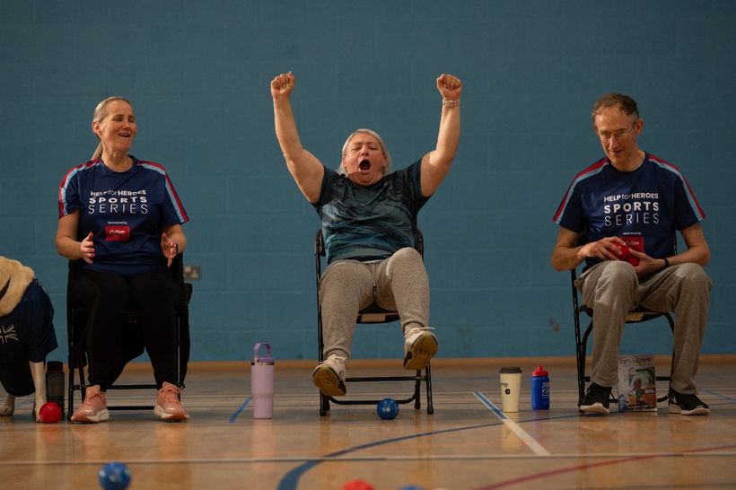 Image shows three veterans seated, playing Boccia