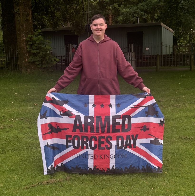 Bradley Cronan is holding an Armed Forces Day flag