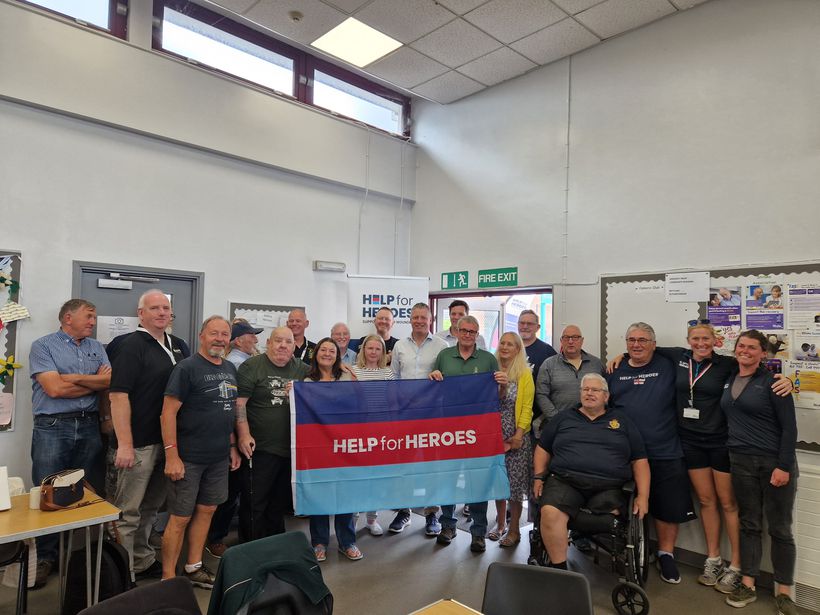 Luke Pollard MP holds Help for Heroes banner with local veterans