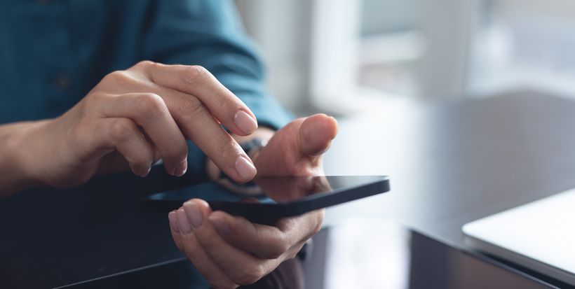 A pair of hands scrolling on a mobile phone