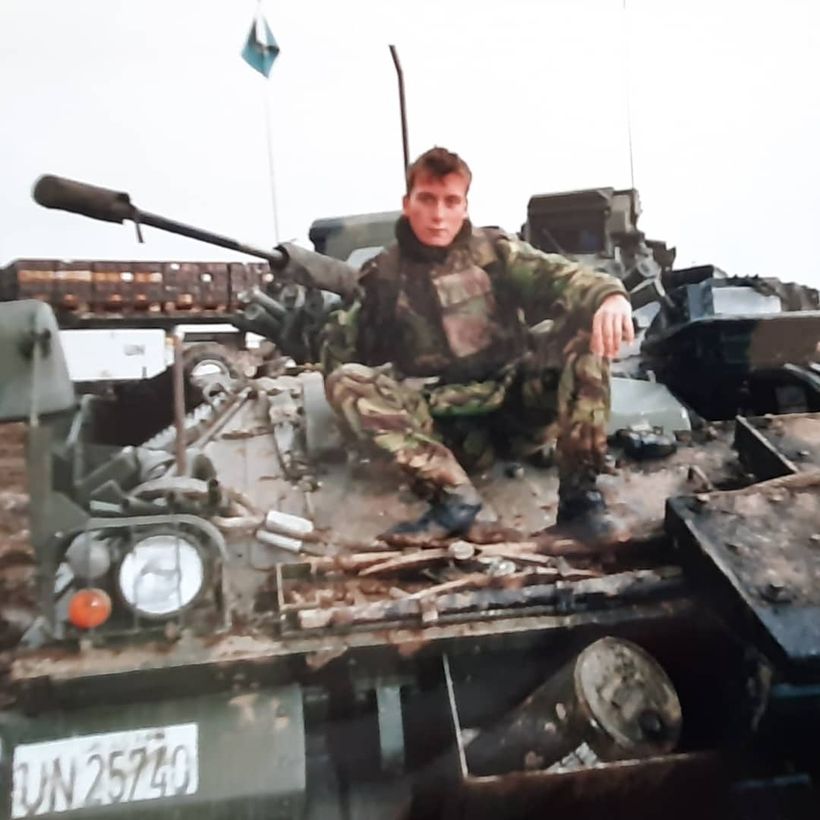 Image shows Tim Stevens sitting on the front of a tank