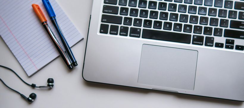 a laptop on a desk with pens