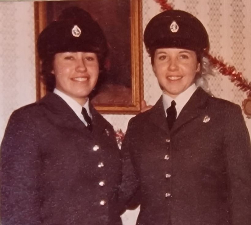 Jean and Jo stand side by side in uniform