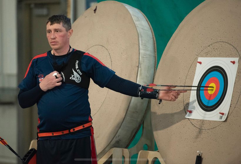Image shows Ben Wilson stood next to an archery target