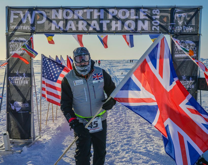 Rob stands at the finish line of the North Pole marathon