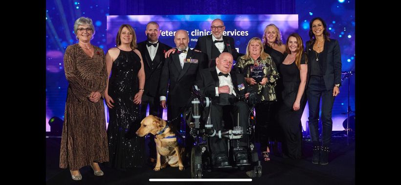 The Veterans' Clinical Services team receive their award, accomp