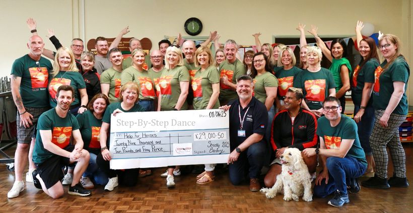 Group of dancers hand over fundraising cheque