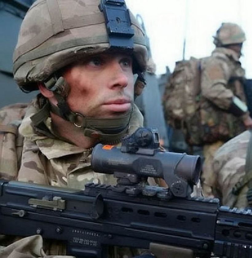 Image shows Captain David Seath in uniform, with a rifle