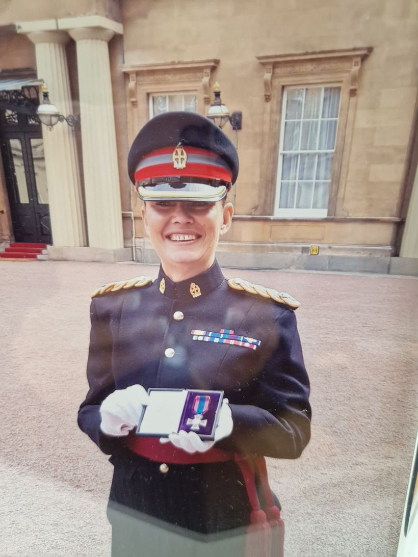 Karen stands proudly in uniform holding her Red Cross medal