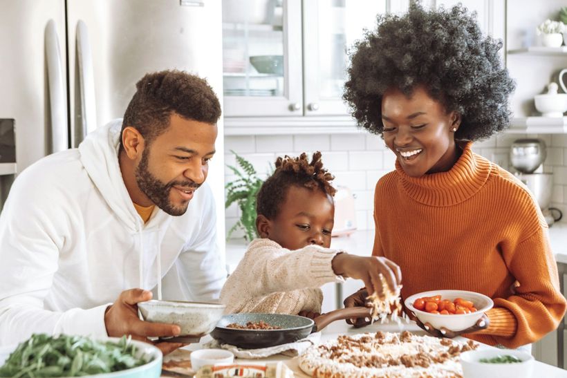 Young family in kitchen happily cooking together