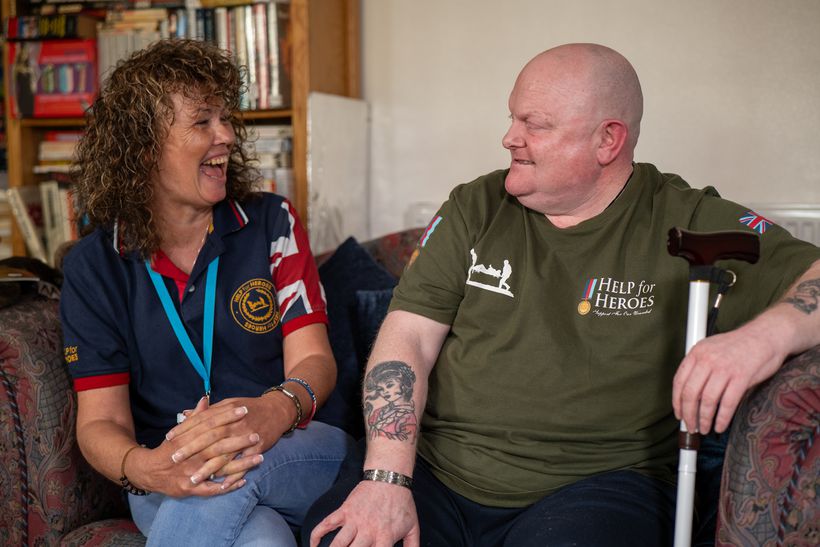 Karen and Shaun sit facing each other talking