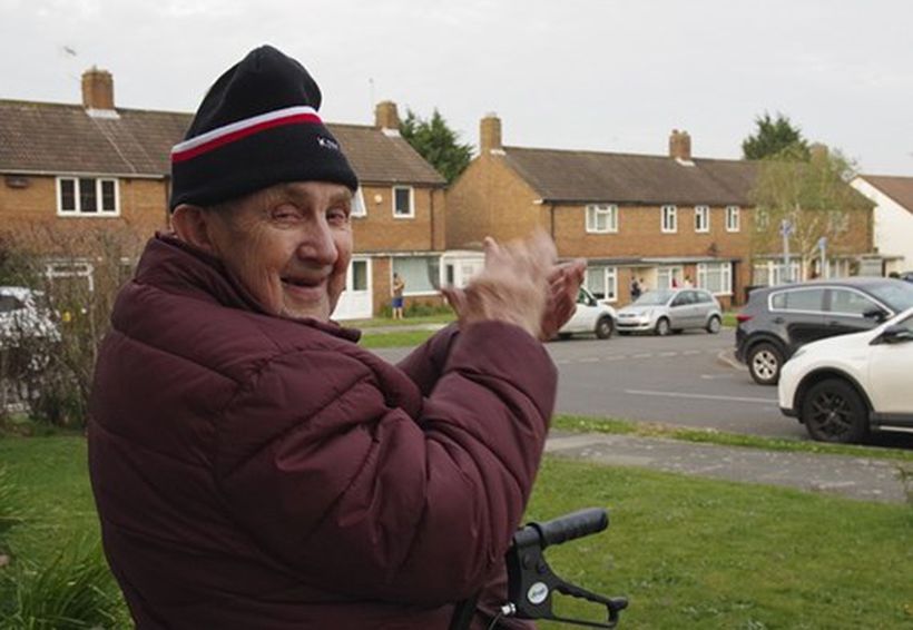 A pensioner clapping for carers outside his home