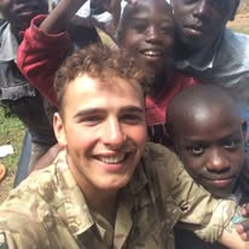Image shows David with a group of children in Kenya