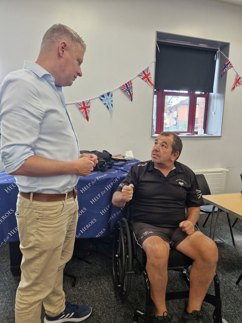 Luke Pollard standing talking to veteran in wheelchair