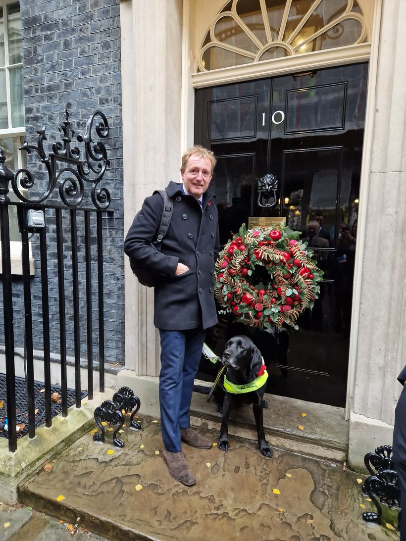 Jamie Weller and guide dog outside black door with Xmas wreath