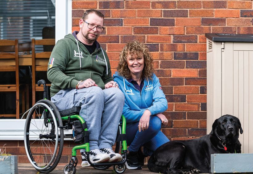 man in garden with his dog and a help for heroes nurse