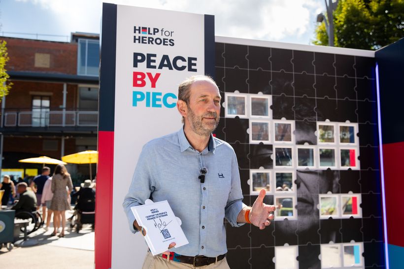 Image of Mark Elliott stood in front of the Peace by Piece stand