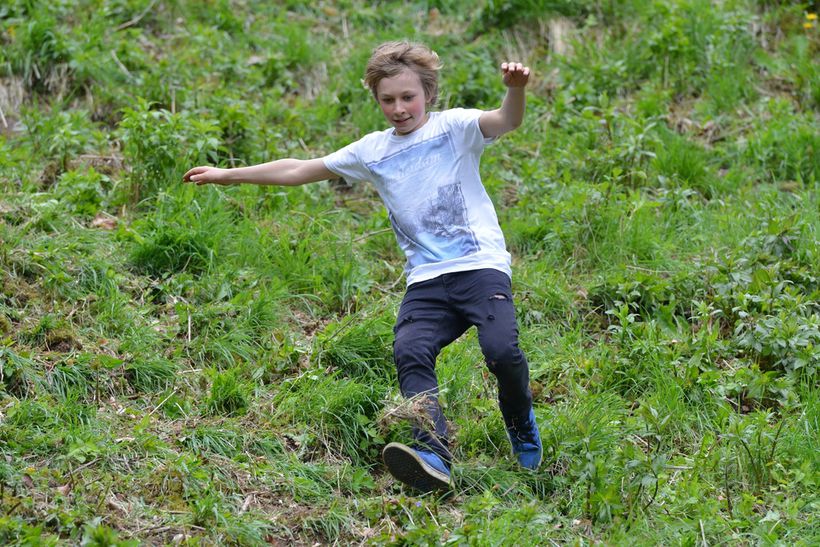 A child running down a grassy hill