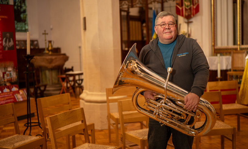 Paul stands proudly holding his tuba
