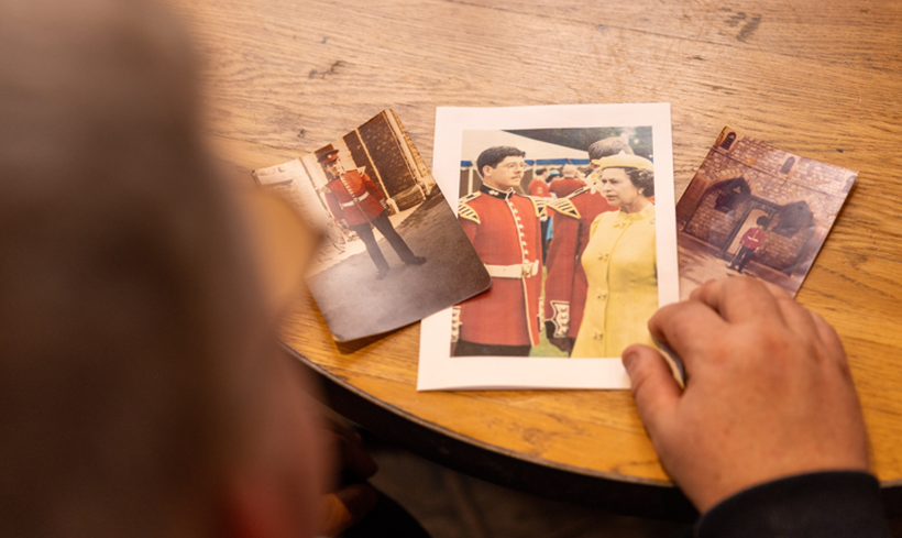 Over shoulder shot of Paul looking at his old military photos
