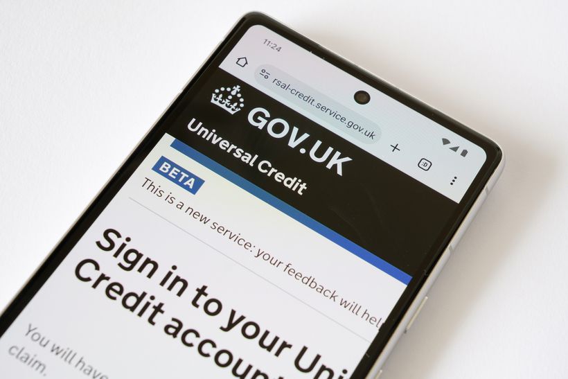 A phone with the UK government's Universal Credit website page.