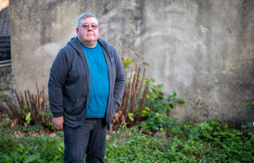 Paul stands outside, alone