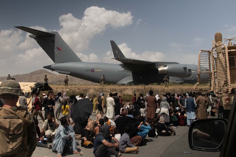 Sitting Afghan evacuees waiting to board plane