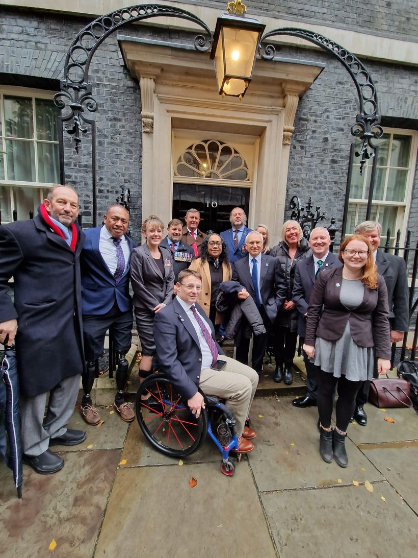 Group of veterans standing together in front of black door