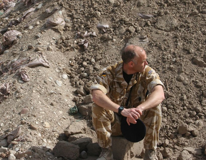 A man in military fatigues looking disconsolate.