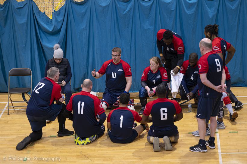 Sitting volleyball team having a team talk.