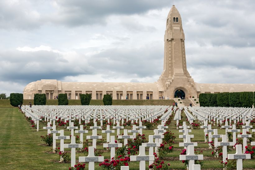 A cemetary on a field with a pillar in the background