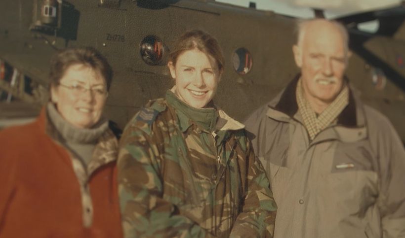 Liz stands with her parents in front of a chinook