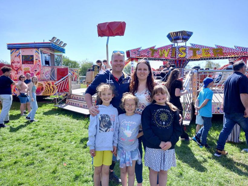 Tony stands with his wife and three young children for a photo