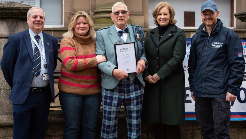 Five people celebrating an award